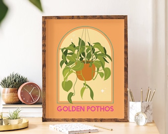 May include: A framed print with a peach background and a yellow archway. A hanging plant with green leaves is inside the archway. The text "GOLDEN POTHOS" is at the bottom of the print.