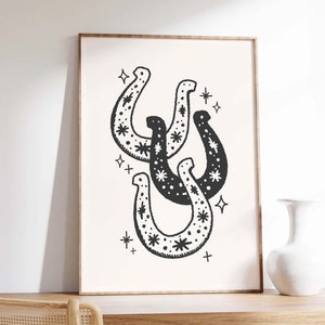 May include: Black and white illustration of three horseshoes with a star pattern. The horseshoes are overlapping and are surrounded by small stars.