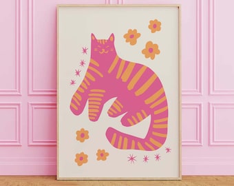 Könnte beinhalten: Ein gerahmter Kunstdruck mit einer stilisierten rosa Katze mit orangefarbenen Streifen, umgeben von orangefarbenen Blumen und Sternen auf cremefarbenem Hintergrund. Das Kunstwerk wird vor einer rosa Wand und einem Holzboden präsentiert.