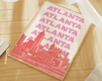 May include: A framed print with a pink and white colour scheme. The print features a cityscape with the word "Atlanta" repeated in pink letters.