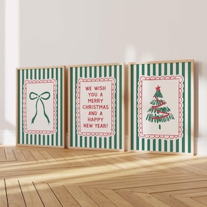 Pode incluir: Três impressões de arte de Natal emolduradas. Cada impressão tem um fundo branco com uma borda vermelha ondulada. As impressões apresentam um laço, texto e um desenho de árvore de Natal. O fundo é listrado em verde e branco.