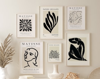 May include: Five black and white art prints with the text "MATISSE" and "PAPIERS DÉCOUPÉS" on a white wall. The prints feature abstract line drawings of a woman, a flower, and a leaf. The prints are framed in white frames.