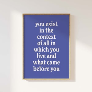 Op de afbeelding: Een blauwe poster met witte tekst die luidt: "Je bestaat in de context van alles waarin je leeft en wat er voor je was."