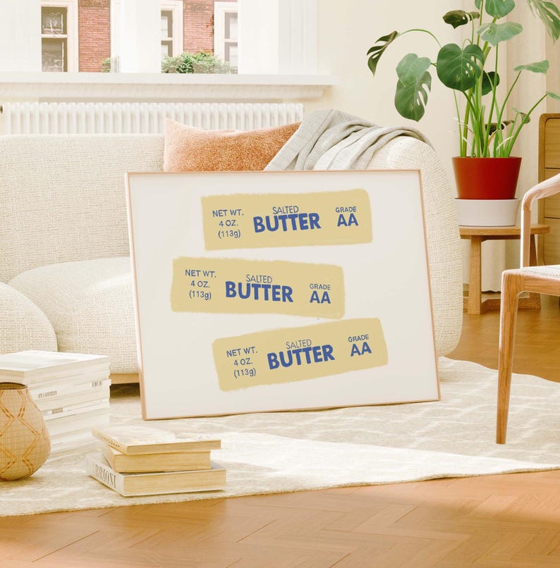 May include: A framed print with three yellow labels that read "NET WT. 4 OZ. (113g) SALTED BUTTER GRADE AA" in blue and white text. The labels are stacked on top of each other.