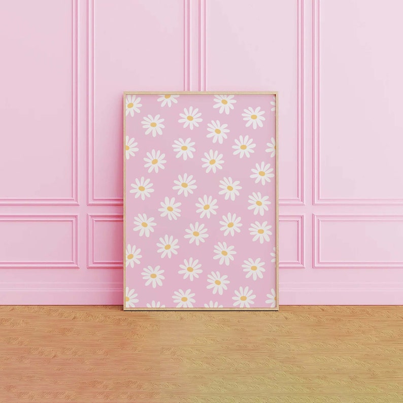 May include: A framed print with a pink background and a repeating pattern of white daisies with yellow centers.