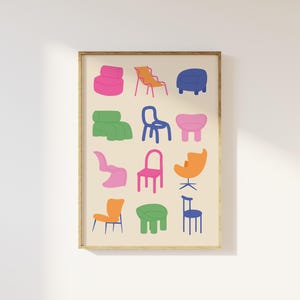 May include: A framed print featuring a collection of colorful, stylized chairs. The chairs are depicted in various shapes and colors, including pink, orange, blue, and green, against a cream-colored background. The artwork is framed in a simple, light brown wooden frame.