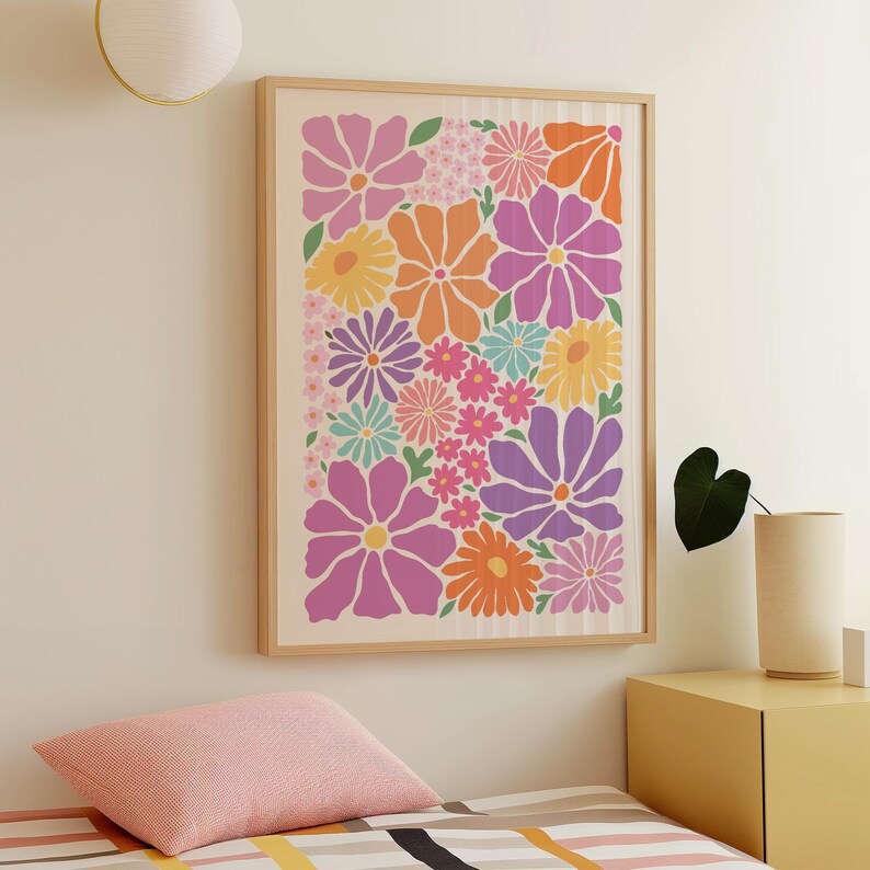 May include: A framed floral art print featuring a vibrant arrangement of stylized flowers in shades of pink, orange, purple, yellow, and blue. The artwork is set against a cream-colored background and framed in a light wood.