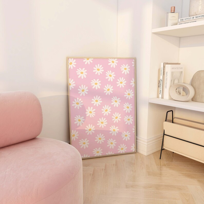 May include: A framed print with a pink background and a repeating pattern of white daisies with yellow centers.