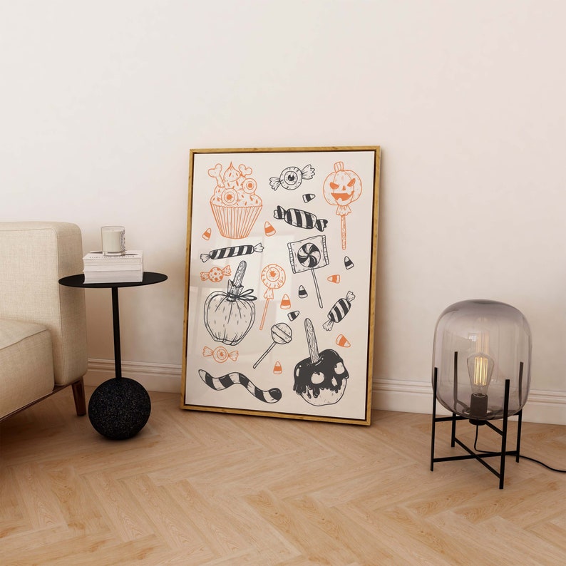 K&ouml;nnte beinhalten: Ein gerahmter Druck mit Halloween-Motiv, der verschiedene schwarze und orangefarbene Illustrationen von S&uuml;&szlig;igkeiten, Cupcakes und K&uuml;rbissen zeigt.
