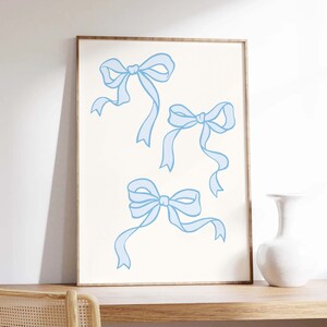 May include: A printable art print featuring three light blue bows on a white background.