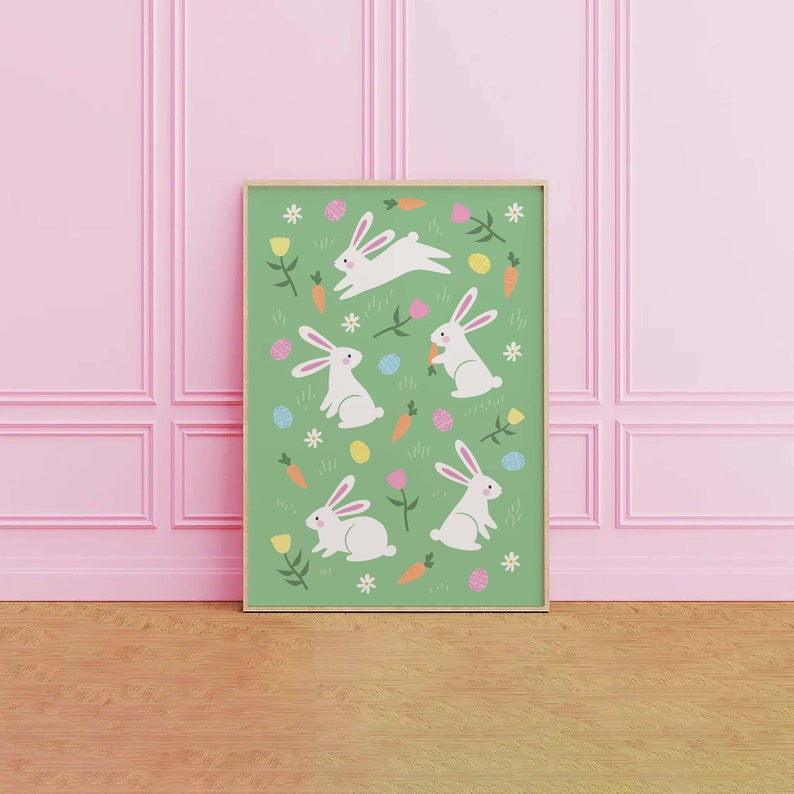 May include: A green framed print with a white background featuring a repeating pattern of white bunnies, carrots, and colorful Easter eggs.
