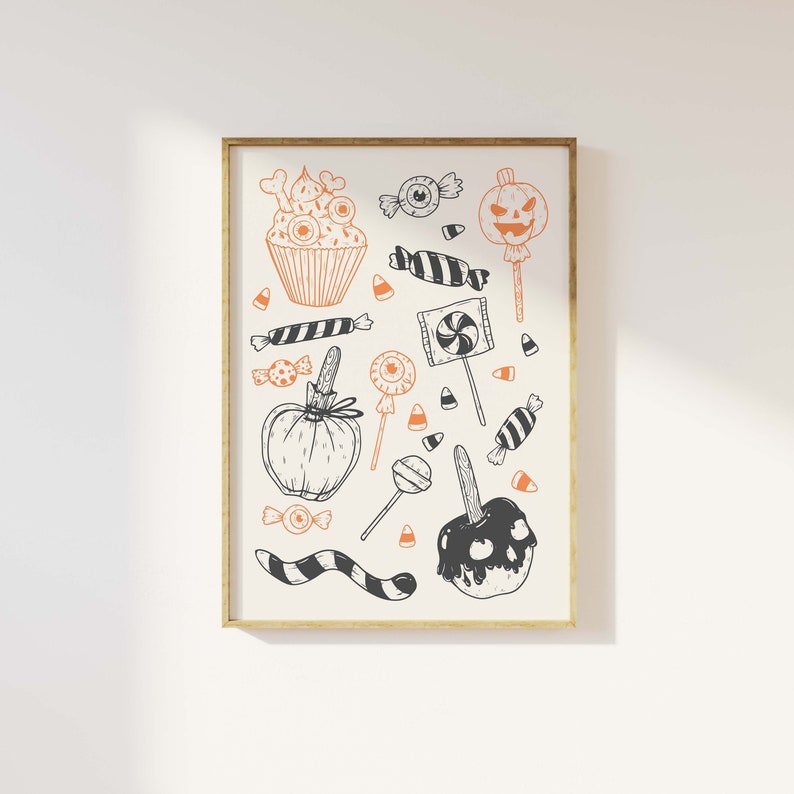 K&ouml;nnte beinhalten: Eine Schwarzwei&szlig;illustration von Halloween-Leckereien, darunter ein Cupcake, Candy Corn, ein K&uuml;rbis, ein Karamellapfel und ein Lollipop. Die Illustration ist in einem goldenen Rahmen gerahmt.