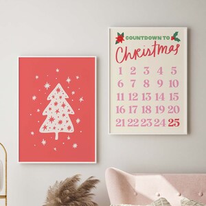 May include: Two framed prints with a Christmas theme. The first print features a white stylized Christmas tree with white stars on a red background. The second print has a white background with the text "COUNTDOWN TO Christmas" in pink and a list of numbers 1-25 in pink.