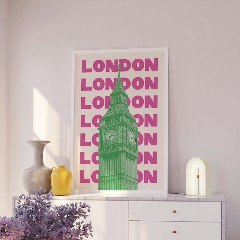 May include: A beige poster with a green image of Big Ben in front of a pink repeating pattern of the word "LONDON".