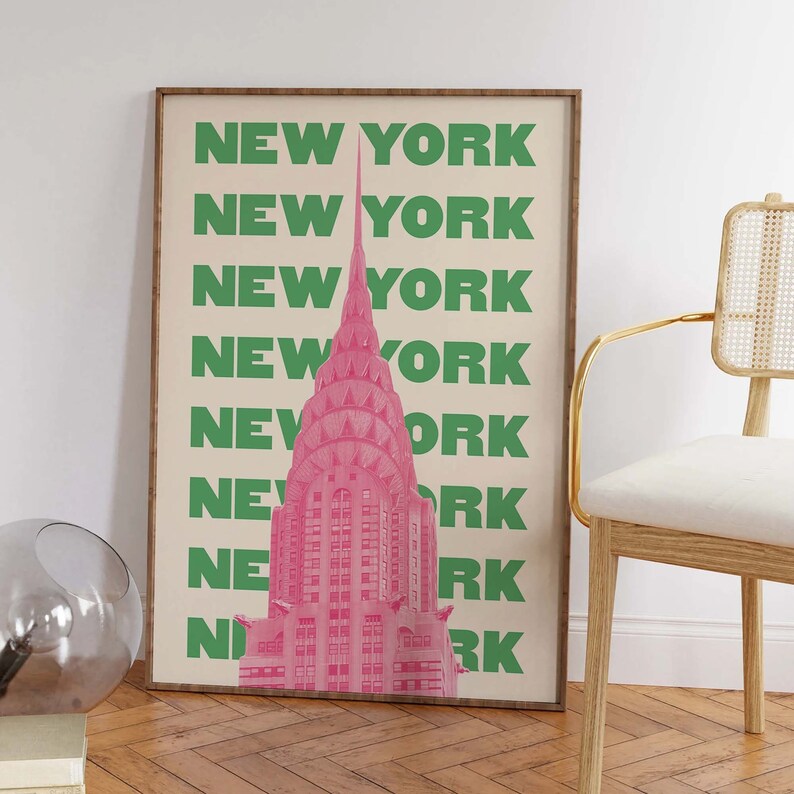 Pu&ograve; includere: Un poster con un'illustrazione rosa del Chrysler Building a New York City. Lo sfondo &egrave; beige con le parole "NEW YORK" ripetute in verde.