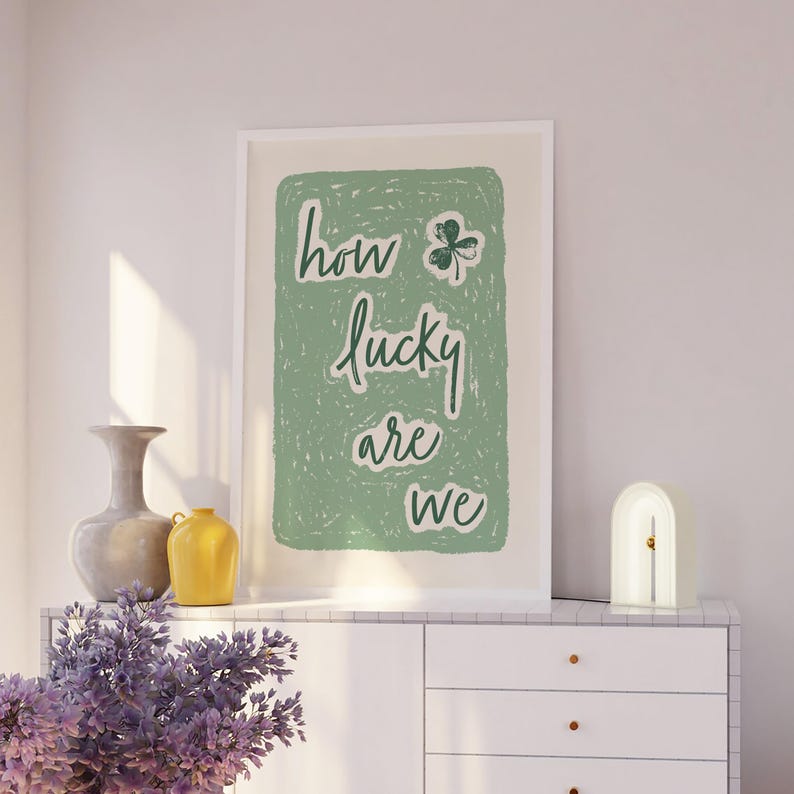 May include: A green and white print with the text "how lucky are we" and a four-leaf clover graphic.