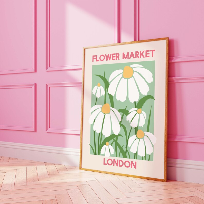 May include: A framed print with a green background and white daisies. The print says "FLOWER MARKET LONDON" in pink and white text.