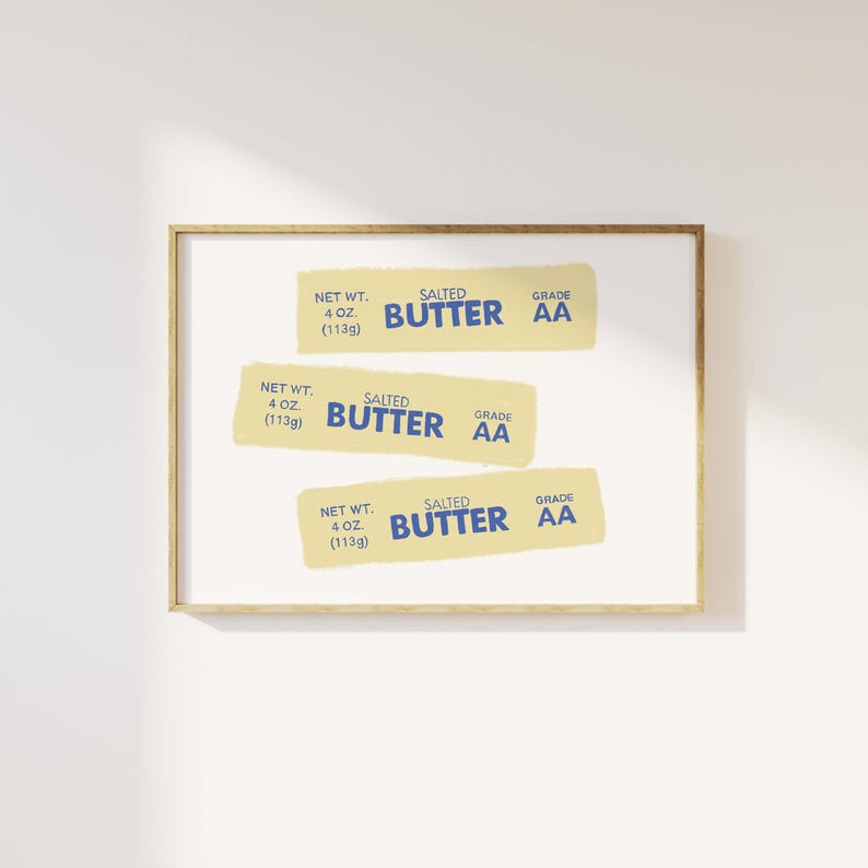 May include: Three yellow and blue labels with the text "SALTED BUTTER GRADE AA" and "NET WT. 4 OZ (113g)" on a white background inside a gold frame.