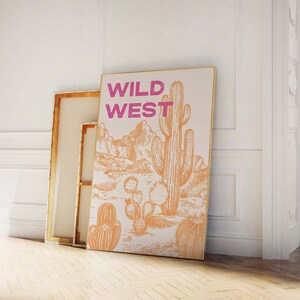 May include: A beige canvas print with a drawing of a desert landscape and a large cactus. The text "WILD WEST" is printed in pink letters at the top of the print.