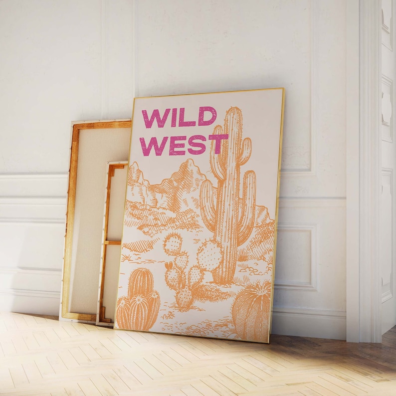 May include: A beige canvas print with a drawing of a desert landscape and a large cactus. The text "WILD WEST" is printed in pink letters at the top of the print.