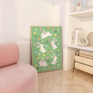 May include: A green poster with a white frame features a repeating pattern of white bunnies hopping and holding carrots on a green background with yellow flowers, pink flowers, and colorful Easter eggs.
