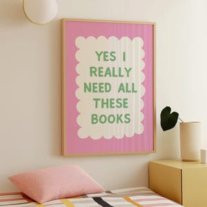 May include: A pink framed print with a white border and the text "YES I REALLY NEED ALL THESE BOOKS" in green letters.