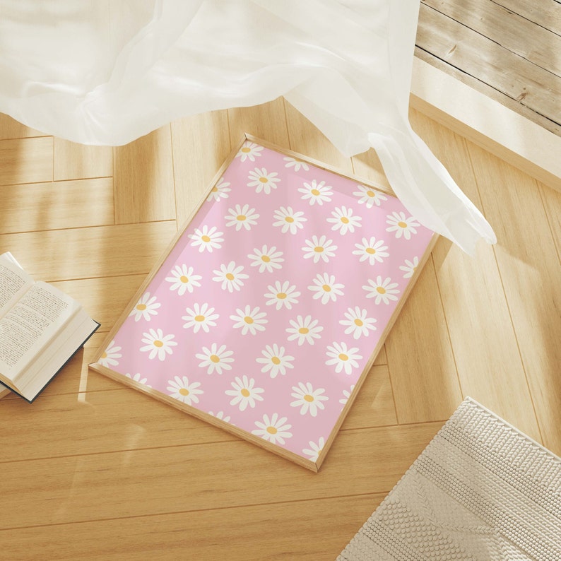 May include: A framed print with a pink background and a white daisy pattern.