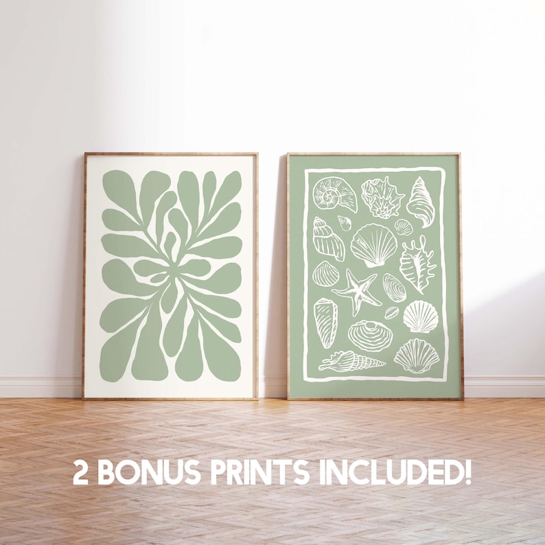 Puede incluir: Dos impresiones art&iacute;sticas enmarcadas. Una presenta un dise&ntilde;o bot&aacute;nico abstracto verde salvia sobre un fondo crema. La otra impresi&oacute;n tiene un fondo verde salvia con ilustraciones de conchas blancas. El texto "2 BONUS PRINTS INCLUDED!" est&aacute; en la parte inferior.
