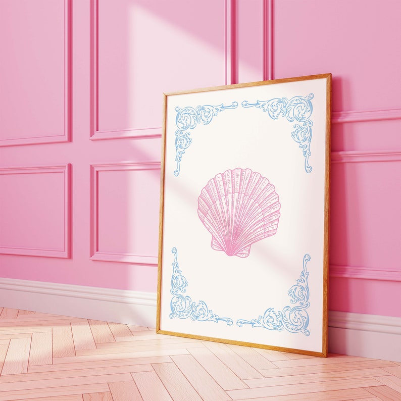 Puede incluir: Una impresi&oacute;n enmarcada con una ilustraci&oacute;n de concha rosa sobre fondo blanco. El marco es dorado y la concha est&aacute; rodeada por un borde decorativo azul.