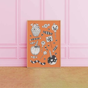 May include: A framed print with an orange background and black and white illustrations of Halloween treats, including candy corn, lollipops, cupcakes, and a jack-o-lantern.