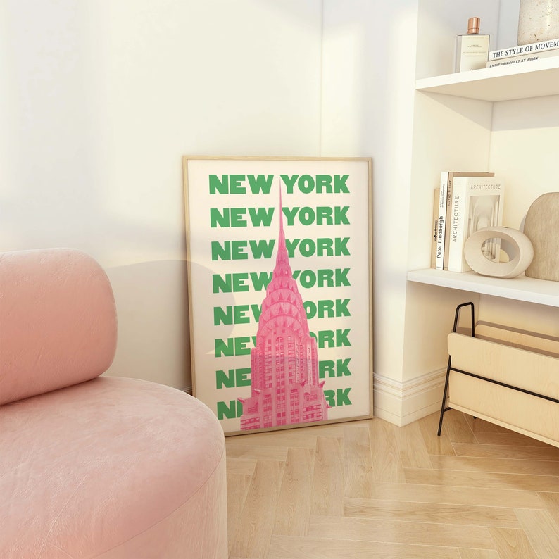 Pu&ograve; includere: Una stampa incorniciata con un'illustrazione rosa del Chrysler Building a New York City. Il testo "NEW YORK" &egrave; ripetuto in lettere verdi lungo il lato della stampa.