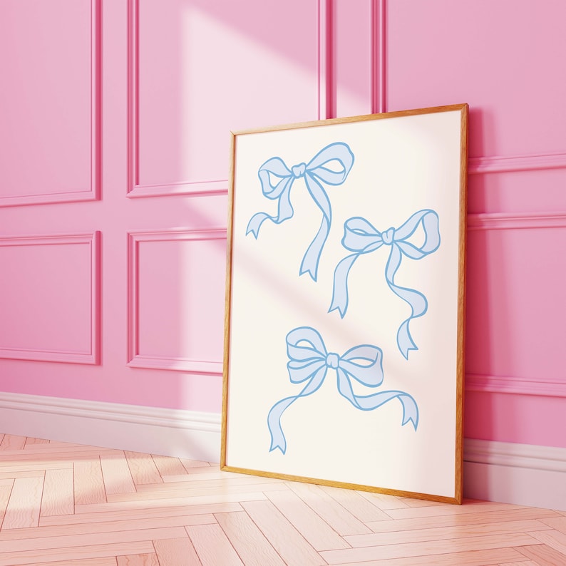 May include: A framed print with a white background and three blue ribbon bows. The bows are drawn in a simple, minimalist style.