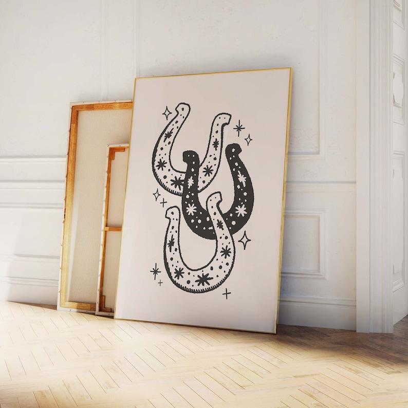May include: A black and white illustration of three horseshoes with a star pattern. The horseshoes are overlapping and are surrounded by small stars.