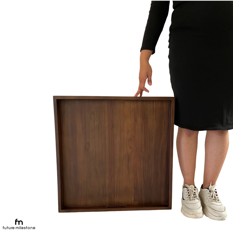May include: A large, rectangular wooden serving tray with a dark brown finish. The tray is made of solid wood and has a smooth surface.
