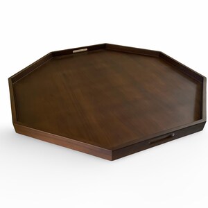 A wooden octagonal serving tray with two handles.
