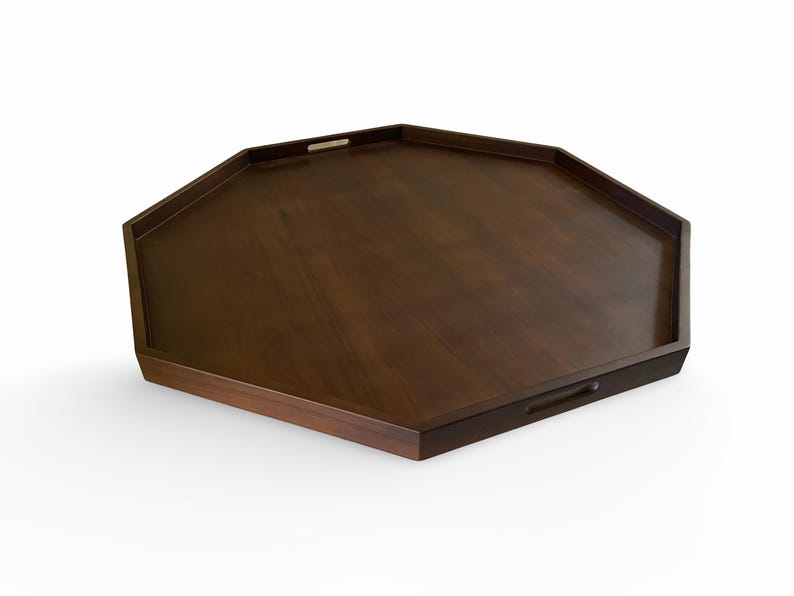 A wooden octagonal serving tray with two handles.