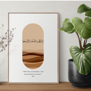 May include: A beige and brown abstract art print with Arabic calligraphy that reads "لا يكلف اللهُ نَفْسًا إِلَّا وَسْعَهَا" and the English translation "Allah does not burden a soul beyond that it can bear".