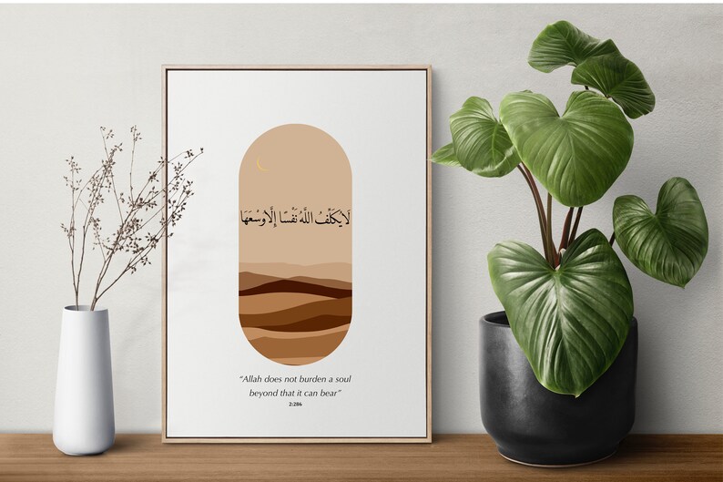 May include: A beige and brown abstract art print with Arabic calligraphy that reads "لا يكلف اللهُ نَفْسًا إِلَّا وَسْعَهَا" and the English translation "Allah does not burden a soul beyond that it can bear".