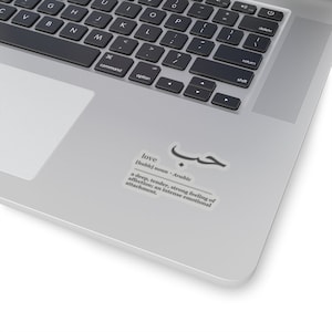 May include: A laptop computer with a sticker that defines the Arabic word for love, "hubb", as a deep, tender, strong feeling of affection. The sticker is on a silver laptop.