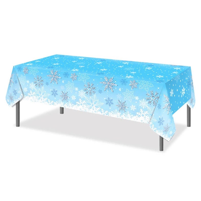 May include: A blue plastic tablecloth with a snowflake pattern. The tablecloth is on a table with silver legs.
