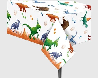 May include: White rectangular tablecloth with a colorful dinosaur print. The design features various dinosaurs in shades of green, blue, and brown, along with eggs, footprints, and party hats. The tablecloth has an orange and brown border.