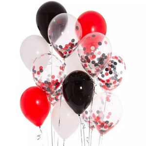 May include: A cluster of balloons in red, black, white, and clear. Some balloons are solid colors, while others are clear with red, black, and white confetti inside. The balloons are tied together with silver ribbons, suitable for a party or celebration.