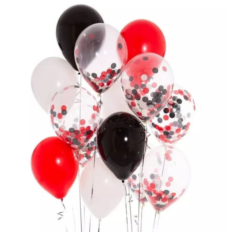 May include: A cluster of balloons in red, black, white, and clear. Some balloons are solid colors, while others are clear with red, black, and white confetti inside. The balloons are tied together with silver ribbons, suitable for a party or celebration.
