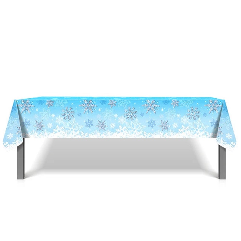 May include: A blue plastic tablecloth with a white snowflake pattern. The tablecloth is laid out on a table with silver legs.