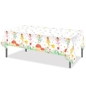 May include: White rectangular tablecloth featuring a repeating pattern of fairies, mushrooms, flowers, and butterflies. The fairies are depicted with colorful wings and dresses. The tablecloth is set on a table with silver legs, suitable for a party or event.