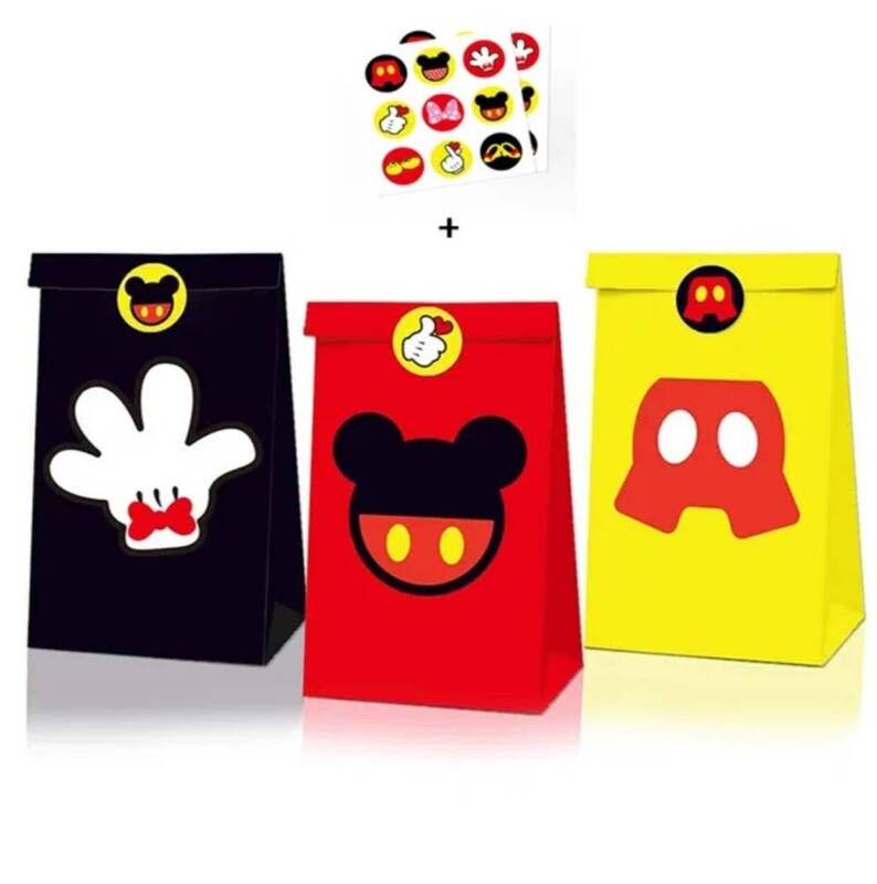 May include: Three small paper gift bags featuring Mickey Mouse character designs. The bags are black, red, and yellow. Each bag has a round sticker with a Mickey Mouse character on it. The stickers are yellow with red and black details.