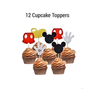 May include: Twelve cupcake toppers featuring Mickey Mouse characters. The toppers are made of felt and include Mickey Mouse ears, gloves, and shorts in red, black, white, and yellow.