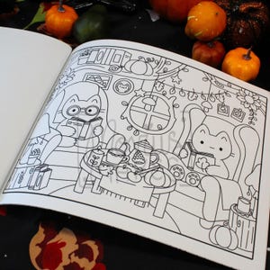 May include: A black and white coloring book page featuring a cozy autumn scene with cartoon cats. One cat wears glasses and reads a book, while another relaxes in a chair. Pumpkins and fall decor surround them, creating a warm, inviting atmosphere.