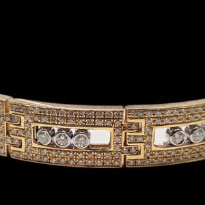 May include: A gold bracelet with a geometric design and a row of small diamonds.