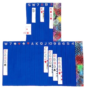 May include: A blue card game with a deck of cards laid out in a grid pattern. The cards are arranged in suits and numbers, with the suits represented by symbols. The cards are labeled with the numbers 2 through 10, Jack, Queen, King, and Ace. The game is called "W7" and is played with a standard deck of 52 cards.